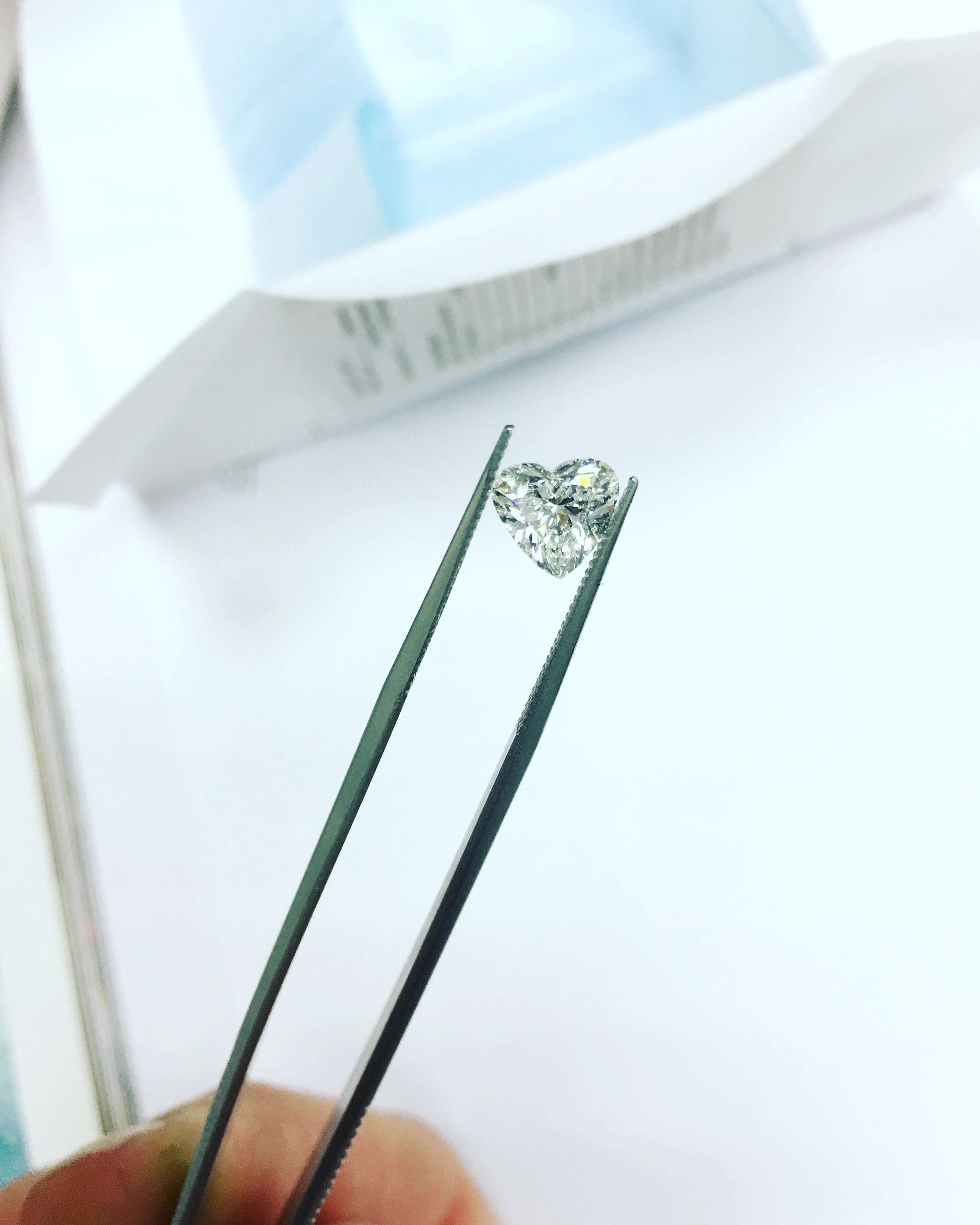 Brilliant cut diamond held in tweezers