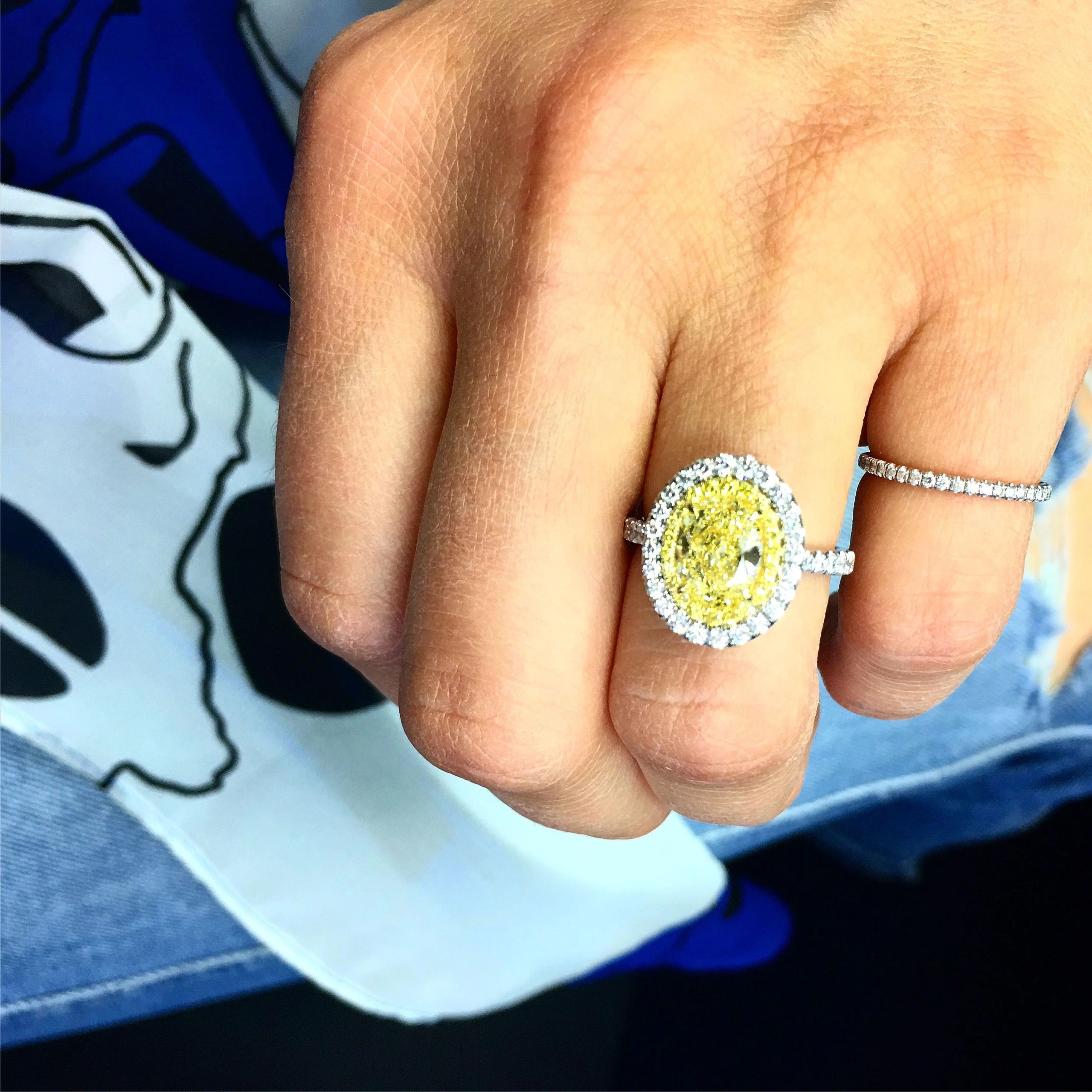 Diamond ring with yellow halo setting on hand